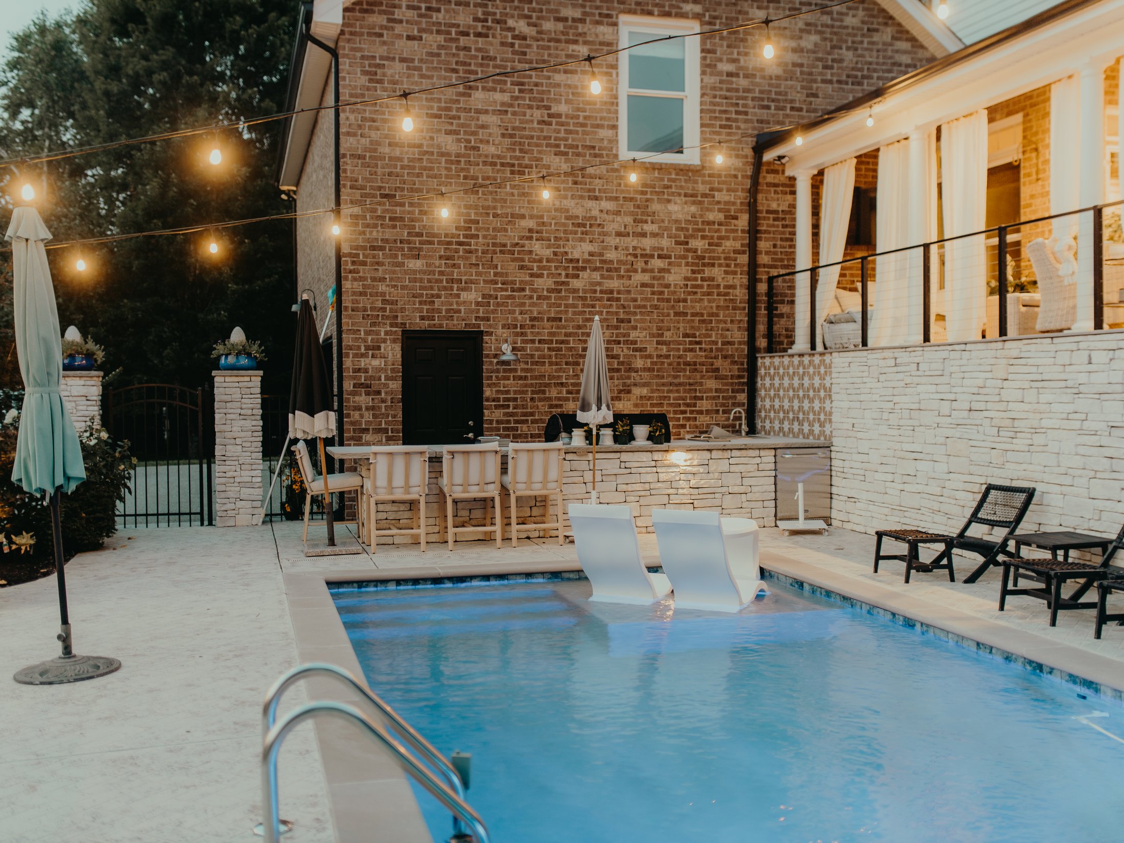 Pool patio under string lights at dusk