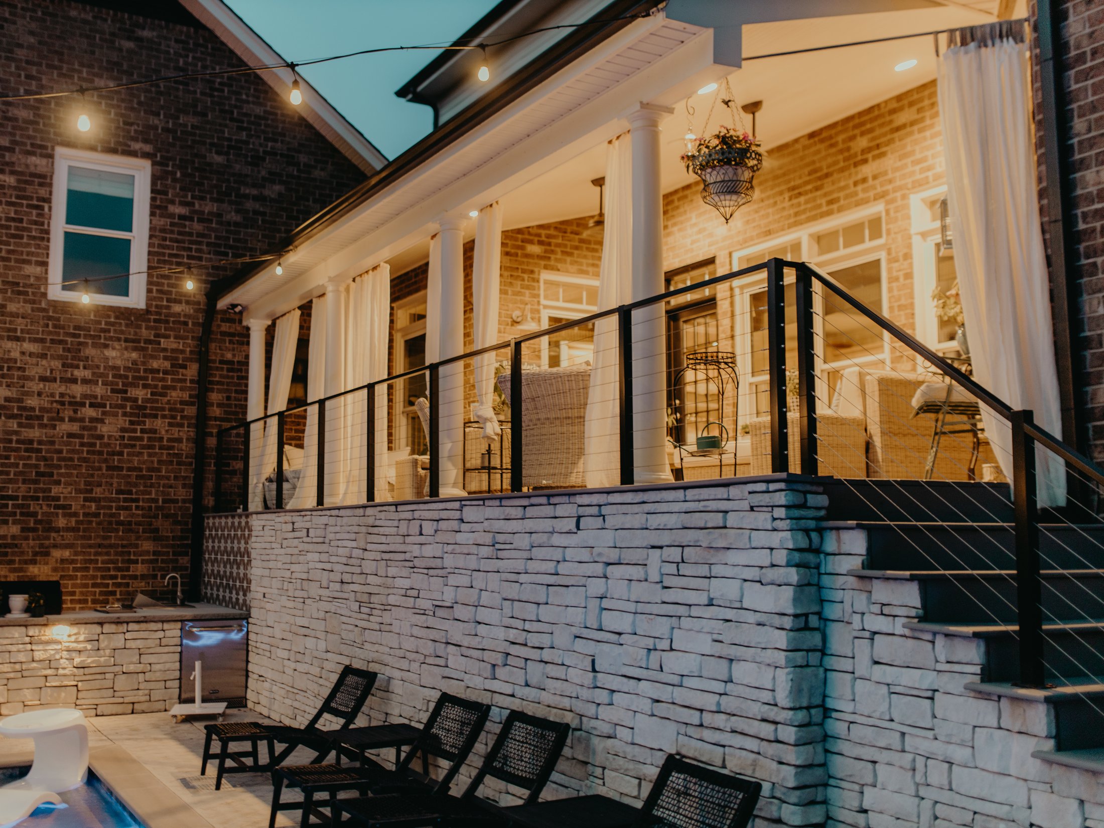 Covered porch and stone wall at dusk