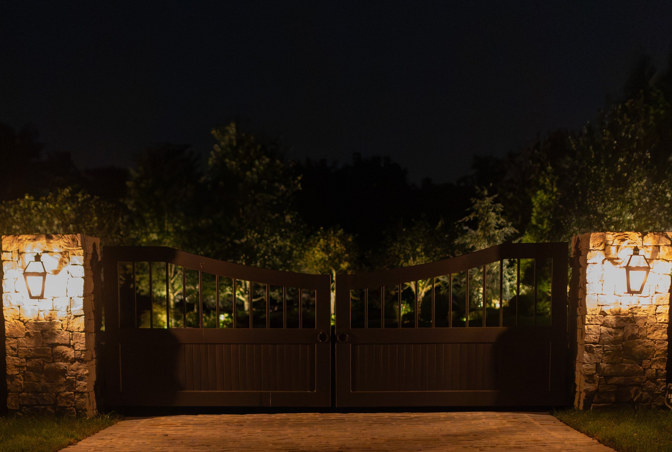 Stone entry gate lit at night