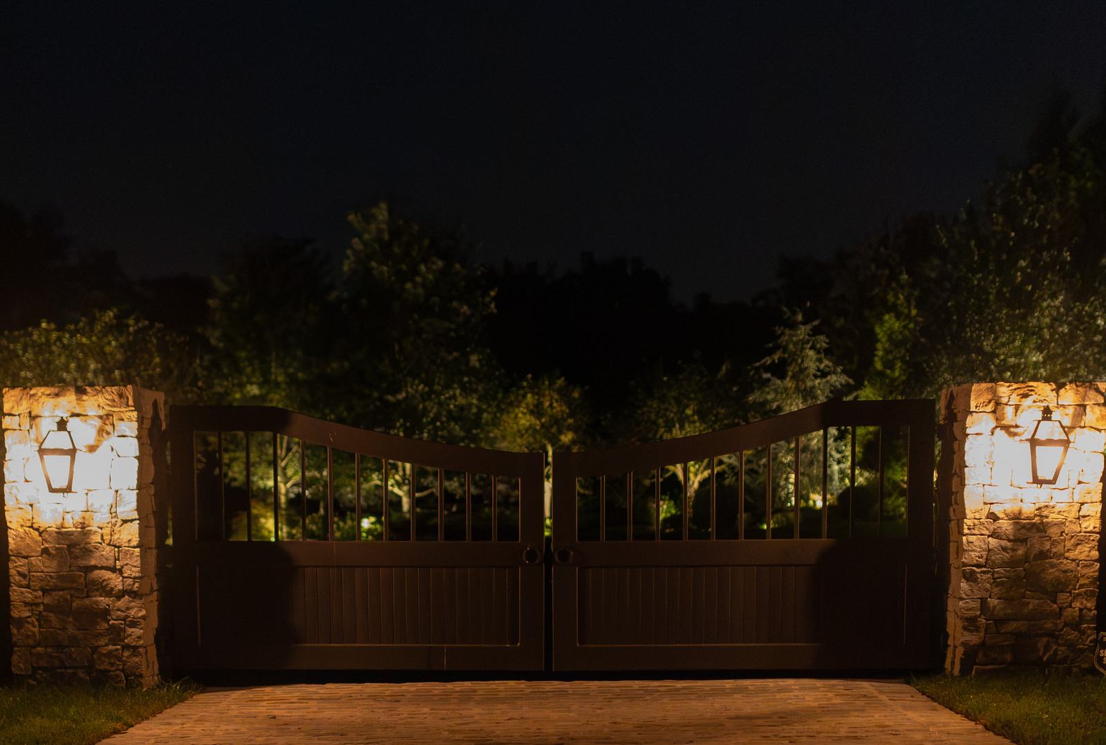 Stone entry gate lit at night